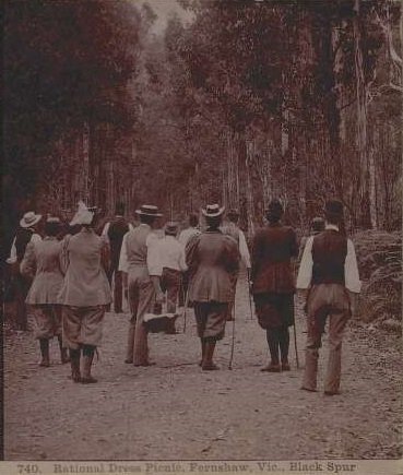 An old photograph of people dressed in practical clothing going for a walk in the bush.